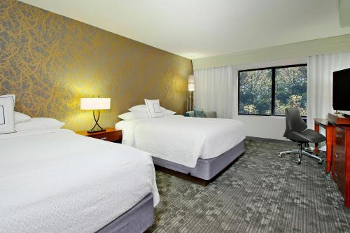 Habitación de hotel con 2 camas y TV de pantalla plana. en Courtyard Atlanta Airport West en Atlanta