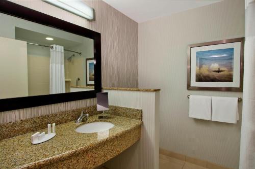 a bathroom with a sink and a mirror at Courtyard Atlanta Airport West in Atlanta