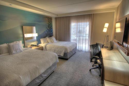 a hotel room with two beds and a television at Courtyard by Marriott Gatlinburg Downtown in Gatlinburg