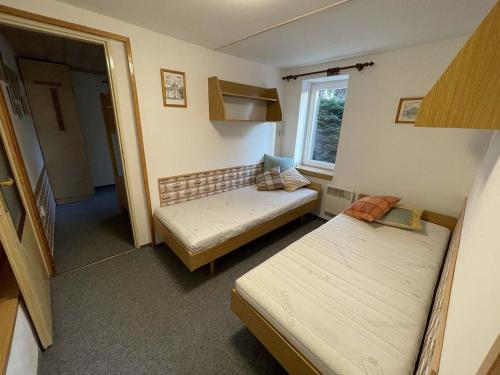 mały pokój z 2 łóżkami i oknem w obiekcie Apartmány U sjezdovky Janské Lázně w Jańskich Łaźniach