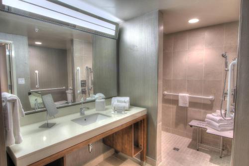 a bathroom with a sink and a large mirror at Courtyard by Marriott Gatlinburg Downtown in Gatlinburg