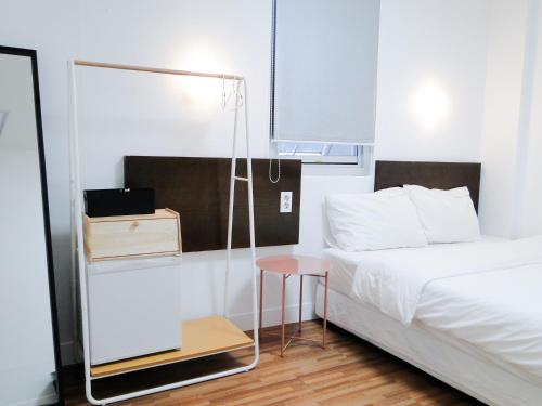 a bedroom with a bed and a table and a mirror at Ekonomy Haeundae Hostel in Busan