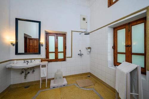 a bathroom with a sink and a mirror at Neemrana's - Baradari Palace in Patiāla