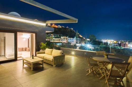 a balcony with a view of a city at night at Frideriki Studios & Apartments in Platanias