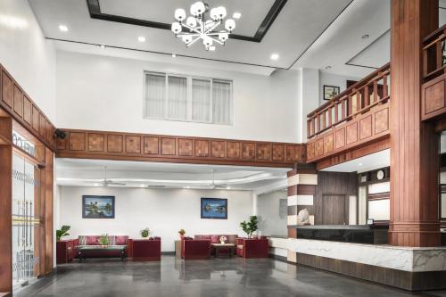 a lobby of a hotel with red furniture and a chandelier at Ohana Phnom Penh Palace Hotel in Phnom Penh