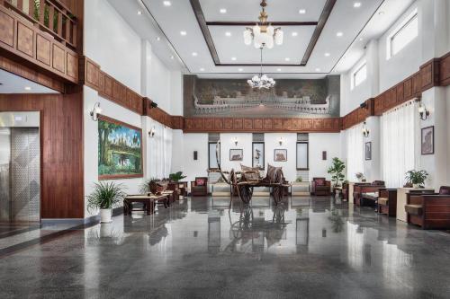 a lobby with tables and chairs and a chandelier at Ohana Phnom Penh Palace Hotel in Phnom Penh