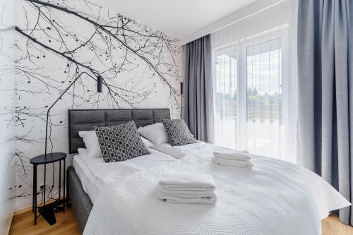 een slaapkamer met een groot bed en handdoeken bij Apartament WIND SurfingBird Dźwirzyno in Dźwirzyno