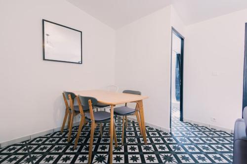 comedor con mesa y sillas en un suelo blanco y negro en T3 pleincentre airconditionné en Burdeos