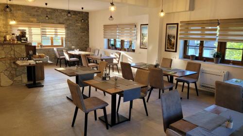 - un restaurant avec des tables et des chaises dans une salle dans l'établissement Plitvica Villa Prica, aux lacs de Plitvice