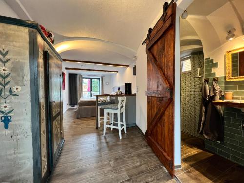um corredor com uma porta e um quarto com uma mesa em Boardingroom Seifersreuth em Grafengehaig