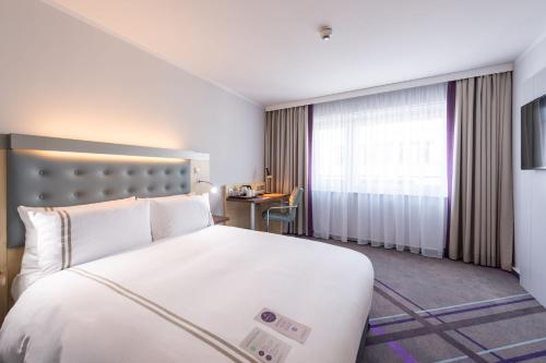 um quarto de hotel com uma cama grande e uma janela em Premier Inn Stuttgart Airport em Leinfelden-Echterdingen