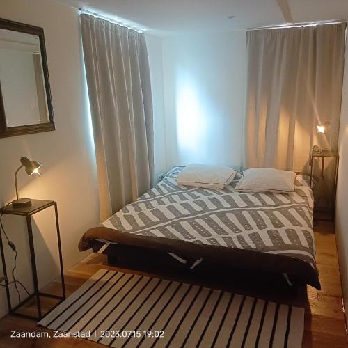 een slaapkamer met een bed met een raam en een tapijt bij Double room in private home in Zaandam