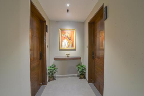 a hallway with two doors and a painting on the wall at Hotel Devgiri Inn and Restaurant in Sangli