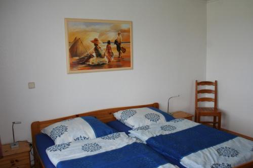 um quarto com uma cama com um quadro na parede em Ferienwohnung Ehmsen em Groß Vollstedt