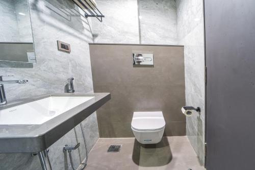 a bathroom with a white toilet and a sink at Hotel Devgiri Inn and Restaurant in Sangli