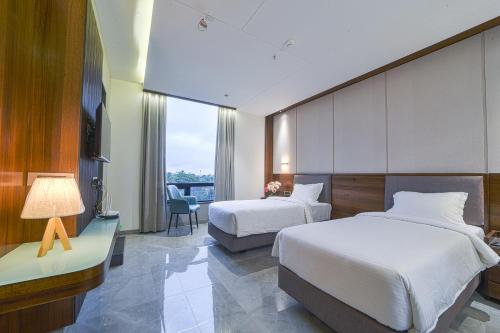 Cette chambre comprend deux lits et un bureau. dans l'établissement Hotel Devgiri Inn and Restaurant, à Sāngli