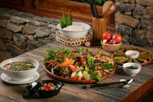 a table with a tray of food and bowls of food at Mai Chau Hideaway Lake Resort in Mai Chau
