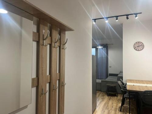 ティラナにあるThyamis Apartmentのテーブルと壁に時計がある部屋