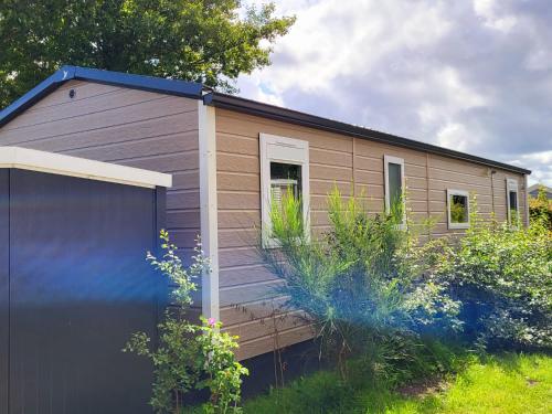 una pequeña casa con un garaje delante en Tussen ´Zee & Meer´ en Lauwersoog