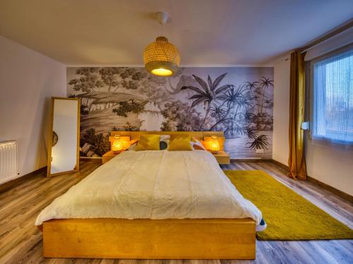 une chambre avec un grand lit et un tableau au mur dans l'établissement LnBnB - Petite maison au cœur de Péronne - Face aux étangs, à Péronne