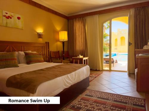 ein Hotelzimmer mit einem Bett und einer Glasschiebetür in der Unterkunft Regency Plaza Aqua Park and Spa Resort in Sharm El Sheikh