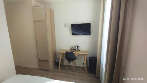 Habitación con mesa, silla y espejo. en Hotel Des Arts, en Rueil-Malmaison
