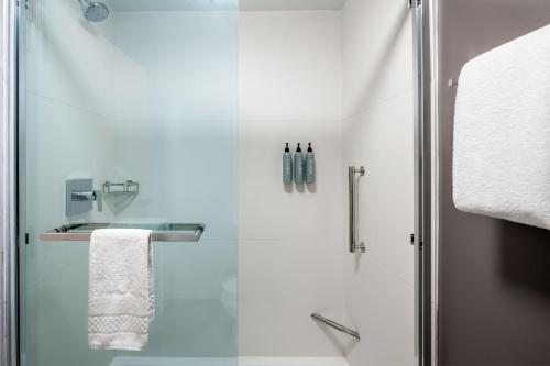 a bathroom with a shower with a glass door at Courtyard by Marriott Charlotte Ballantyne in Charlotte