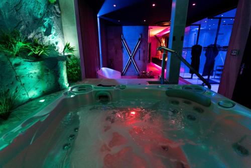 a jacuzzi tub in the middle of a room at Les Secrets Rooms - Bonneval - Love Room - Spa et Hammam Privatif in Bonneval