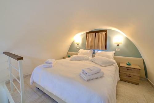 a bedroom with a large bed with towels on it at Ifestos Villa in Fira