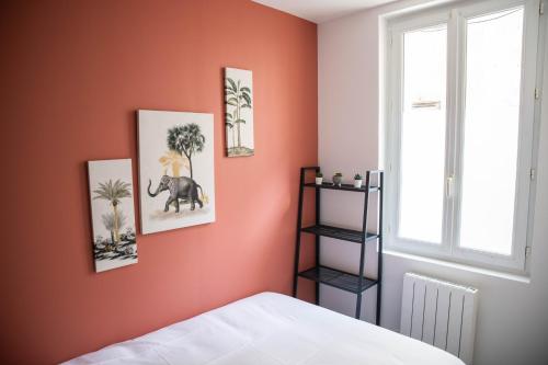 een slaapkamer met oranje muren en een wit bed bij Appartements de caractère centre - WIFI - PARKING in Niort
