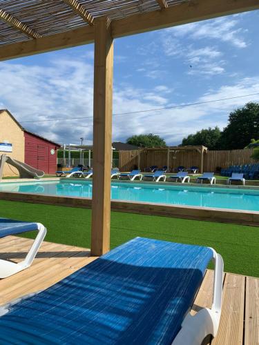 - une vue sur la piscine depuis la terrasse dotée d'une table et de chaises dans l'établissement THITOME, à Limeuil