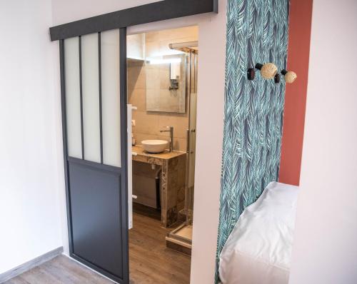 een badkamer met een deur naar een slaapkamer met een wastafel bij Appartements de caractère centre - WIFI - PARKING in Niort