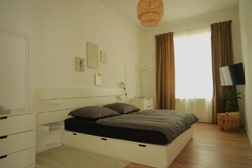 um quarto branco com uma cama e uma janela em Apartment Edda em Senftenberg