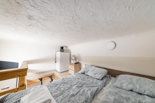 sypialnia z łóżkiem i białą ścianą w obiekcie Micro Apartments 2,5 qm - Najmniejsze Apartamenty Świata 2,5 mkw w Krakowie