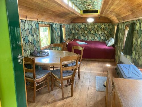 Zimmer mit einem Tisch und einem Bett in einem Anhänger in der Unterkunft Ecostay de Wildernis in Wilp