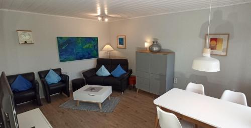 a living room with a couch and chairs and a table at Komfortabler Bungalow, Husen 15 , 2 bis 4 Personen, Europa-Feriendorf in Husen