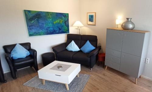 sala de estar con sofá y 2 sillas en Komfortabler Bungalow, Husen 15 , 2 bis 4 Personen, Europa-Feriendorf en Husen