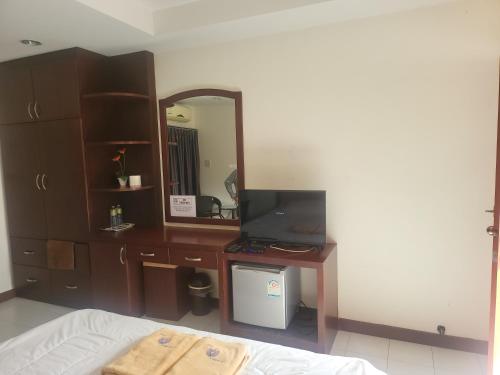 a bedroom with a desk and a mirror and a bed at EKALUK PLACE INN in North Pattaya