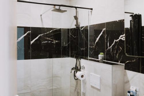 a bathroom with black and white tiles on the wall at MY HOME ADDL in Štrigova