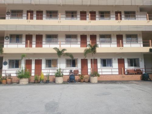 a large building with a lot of windows and plants at EKALUK PLACE INN in North Pattaya