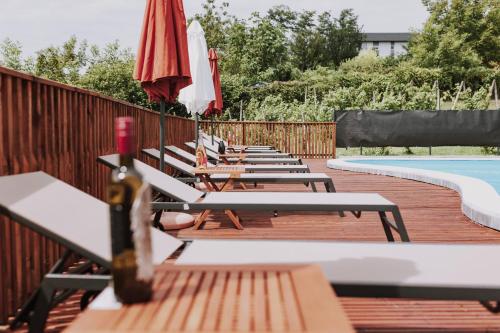 a row of wooden benches next to a swimming pool at MY HOME ADDL in Štrigova