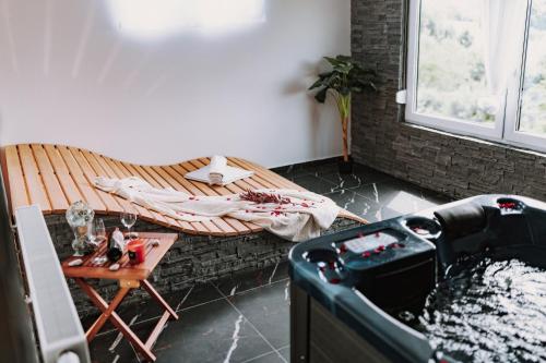 a room with a bath tub with a table and a table sidx sidx at MY HOME ADDL in Štrigova