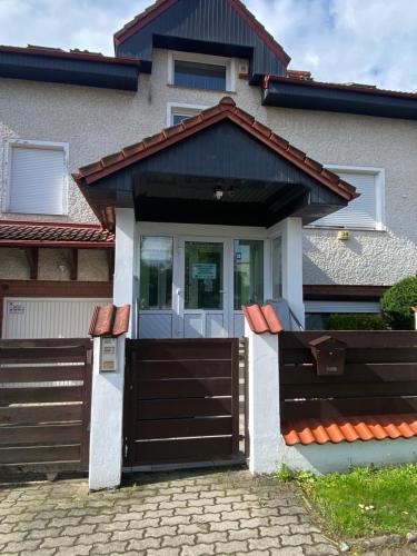 a house with a brown door and a fence at AS Pomorze in Gdańsk