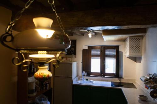 una cocina con una luz colgada del techo en casa rural La Morucha de Hervás en Hervás