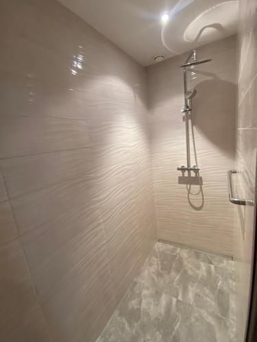 y baño con cabina de ducha y suelo de baldosa. en AS Pomorze, en Gdansk