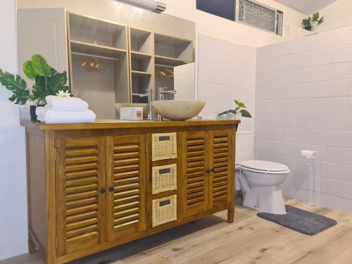 a bathroom with a sink and a toilet at Taharu'u Guest House By The Beach in Papara