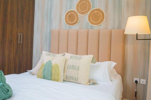 a bedroom with a bed with pillows and a lamp at Exquisite Villa - Elegant Living in Dubai