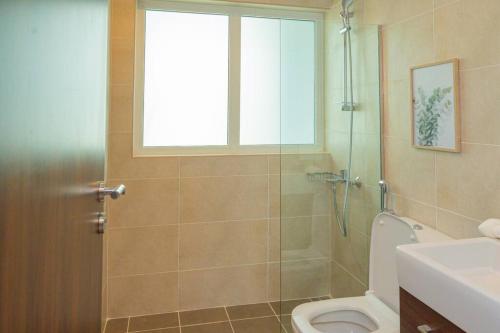 a bathroom with a shower and a toilet and a window at Exquisite Villa - Elegant Living in Dubai