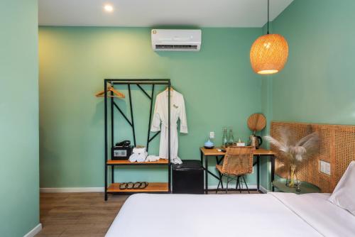 a bedroom with a bed and a table with a mirror at Leaf Hotel Phu Quoc in Phu Quoc