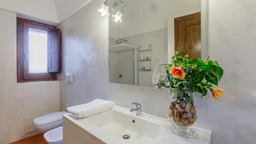 a bathroom with a sink and a vase of flowers at Tenuta Bukkuram in Pantelleria